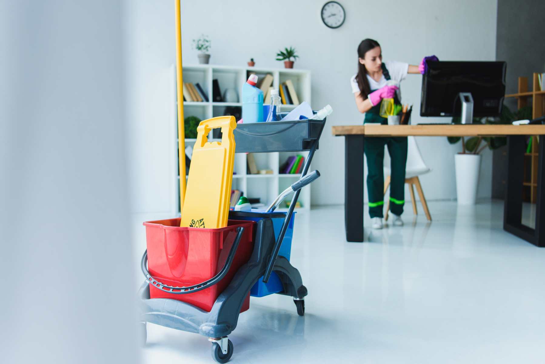 young female janitor cleaning office